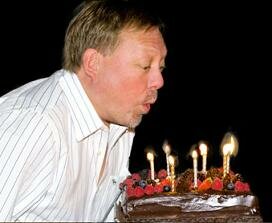 man blowing out a cake