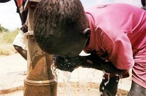 boy drinking from outside tap